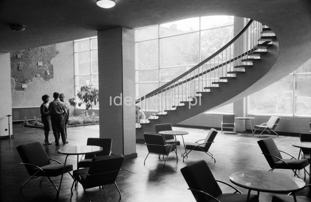 Ujęcie na parter hotelowego lobby, z którego do góru prowadzą spiralne schody.