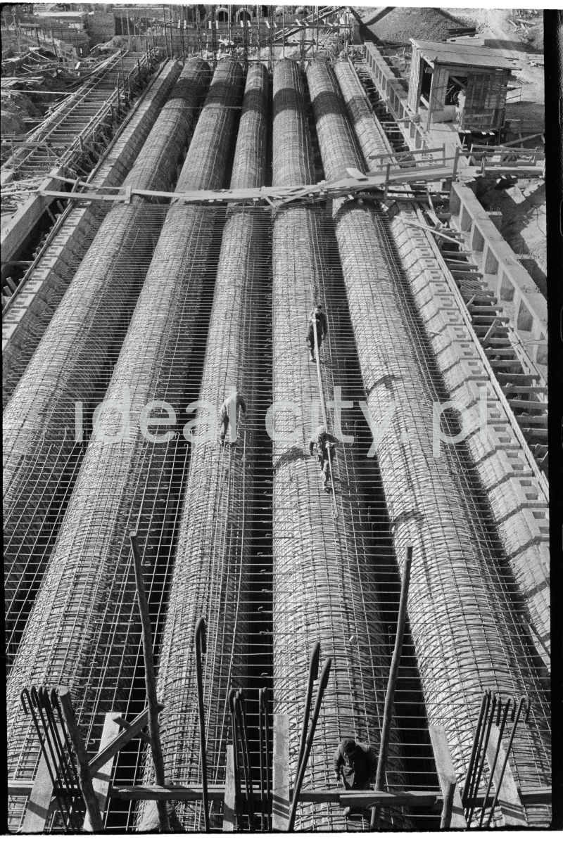 A view from above on the huge pipes covered with reinforcements lying next to each other on the ground.