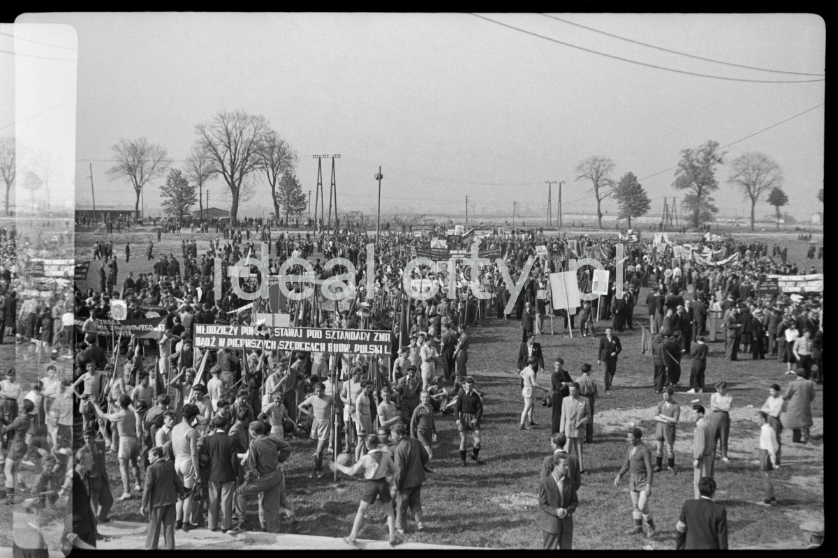 The crowd gathered on the meadow with banners prepares for the march.