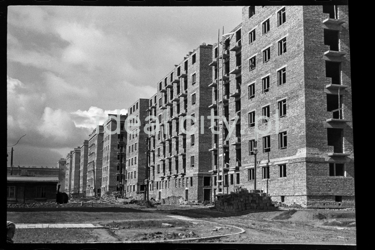 The shot shows a newly completed brick apartment block in a rough state.