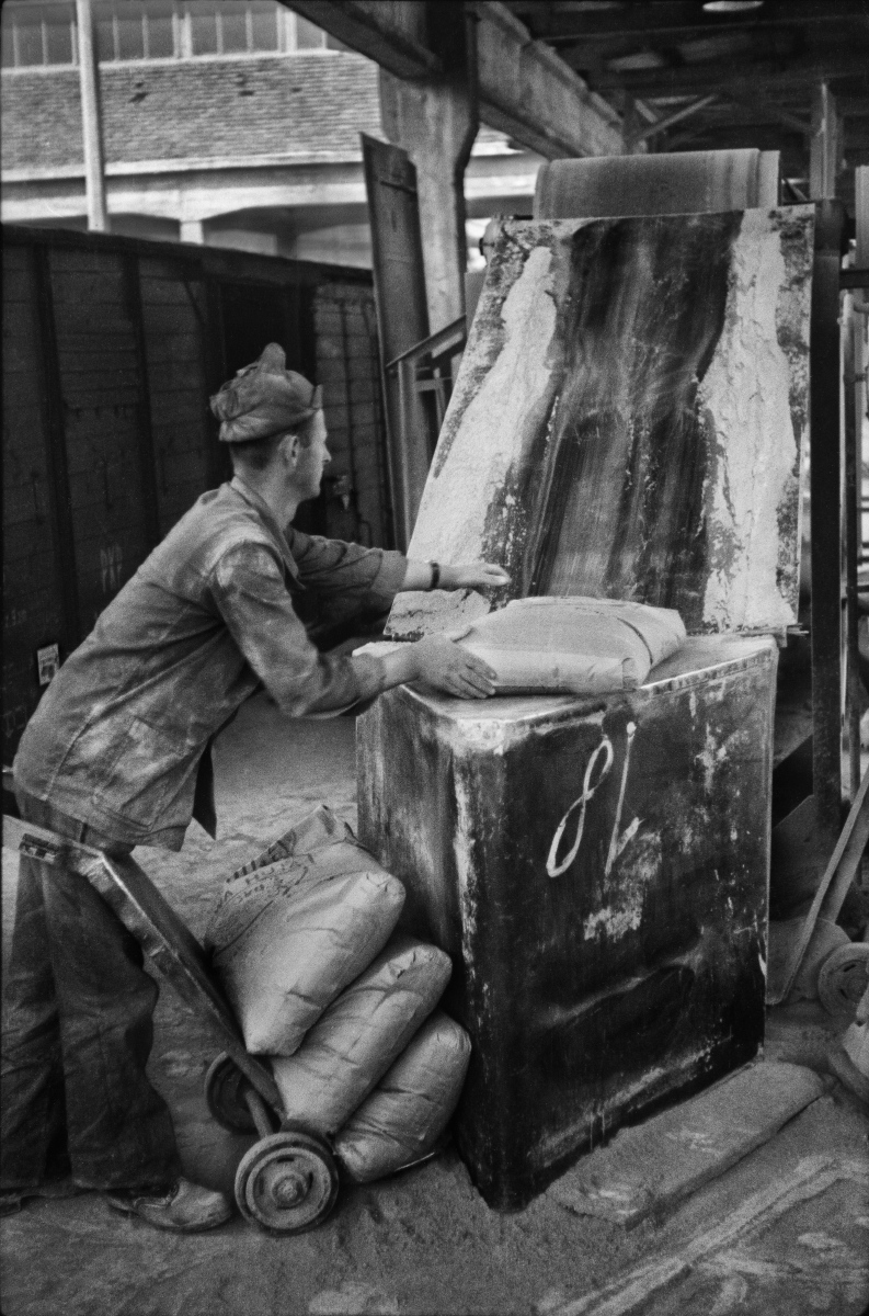 The worker throws large sacks onto the conveyor belt.