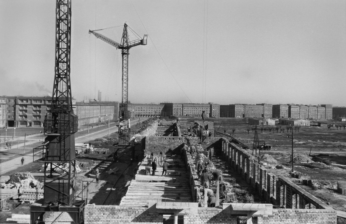 A perspective view from a height for the construction of the foundations of a residential block, completed residential buildings on the horizon.