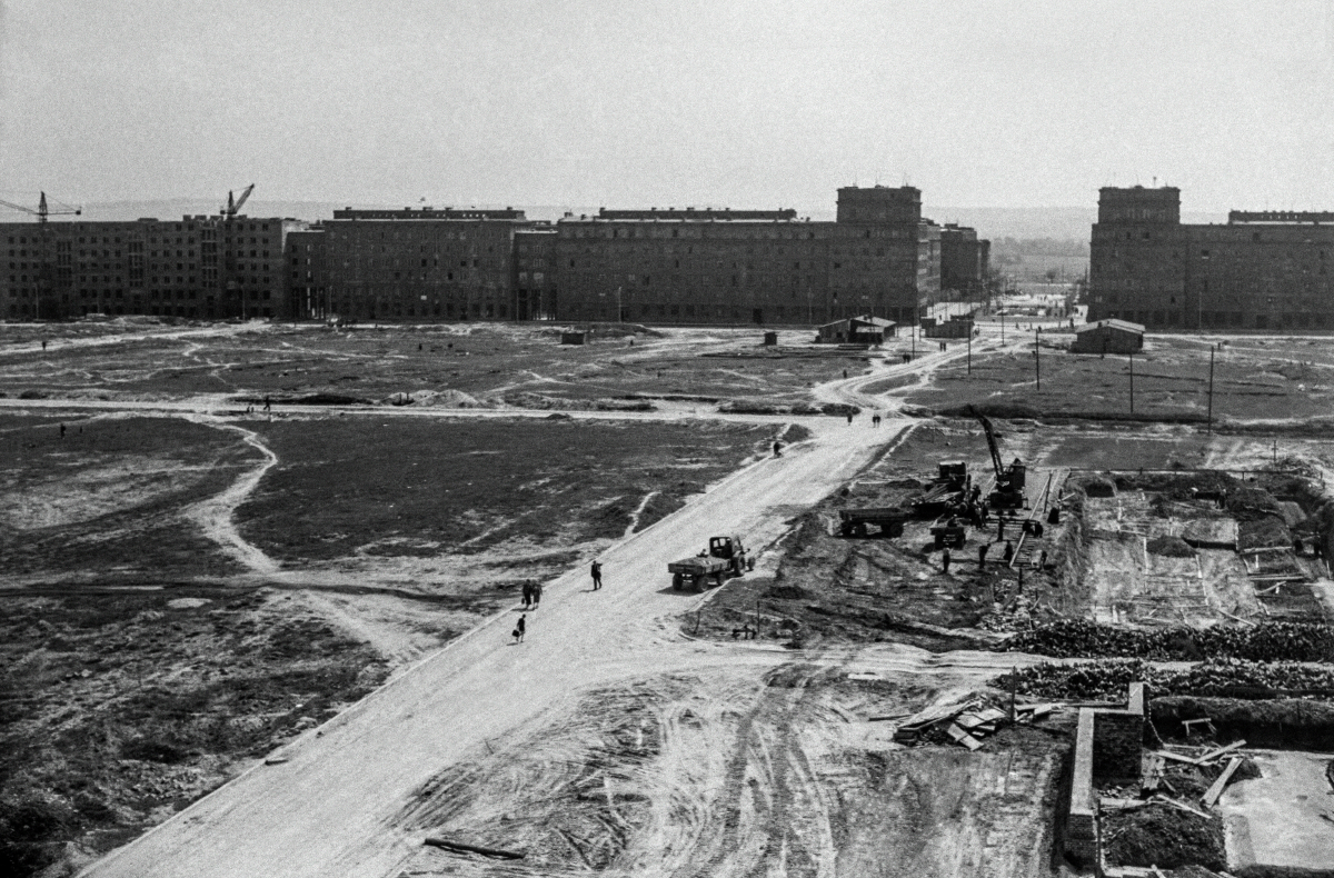 View of the construction site from a height, monumental residential buildings completed in the background.