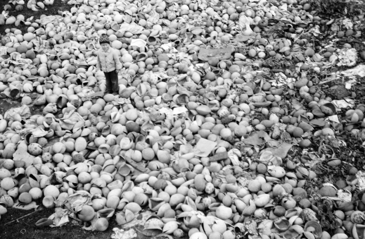 A child in the middle of a pile of broken balls.