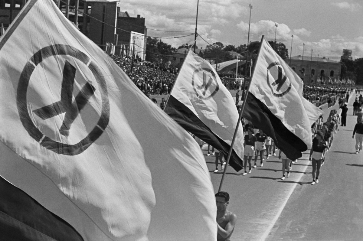 The marchers carry flags with the letter K.