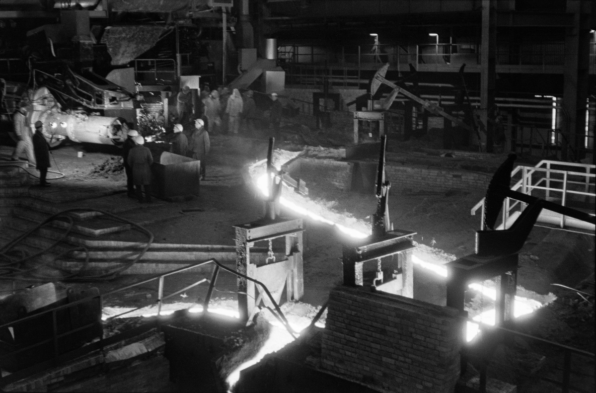 A shot from above on a stream of pig iron, around a few men in helmets.