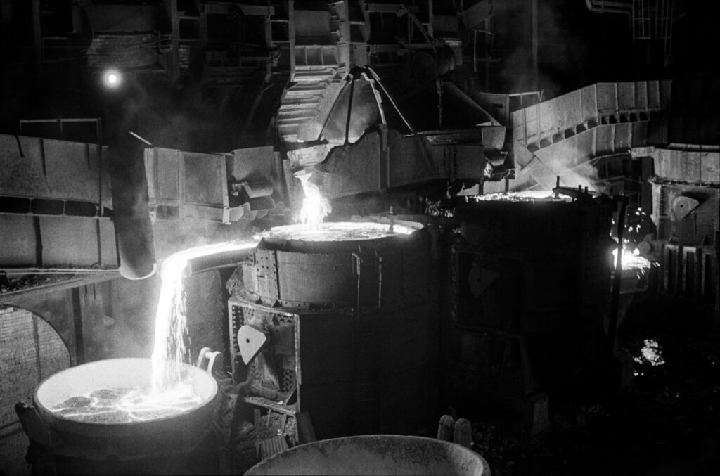 The hot pig iron flows from the ladle into the ladle.