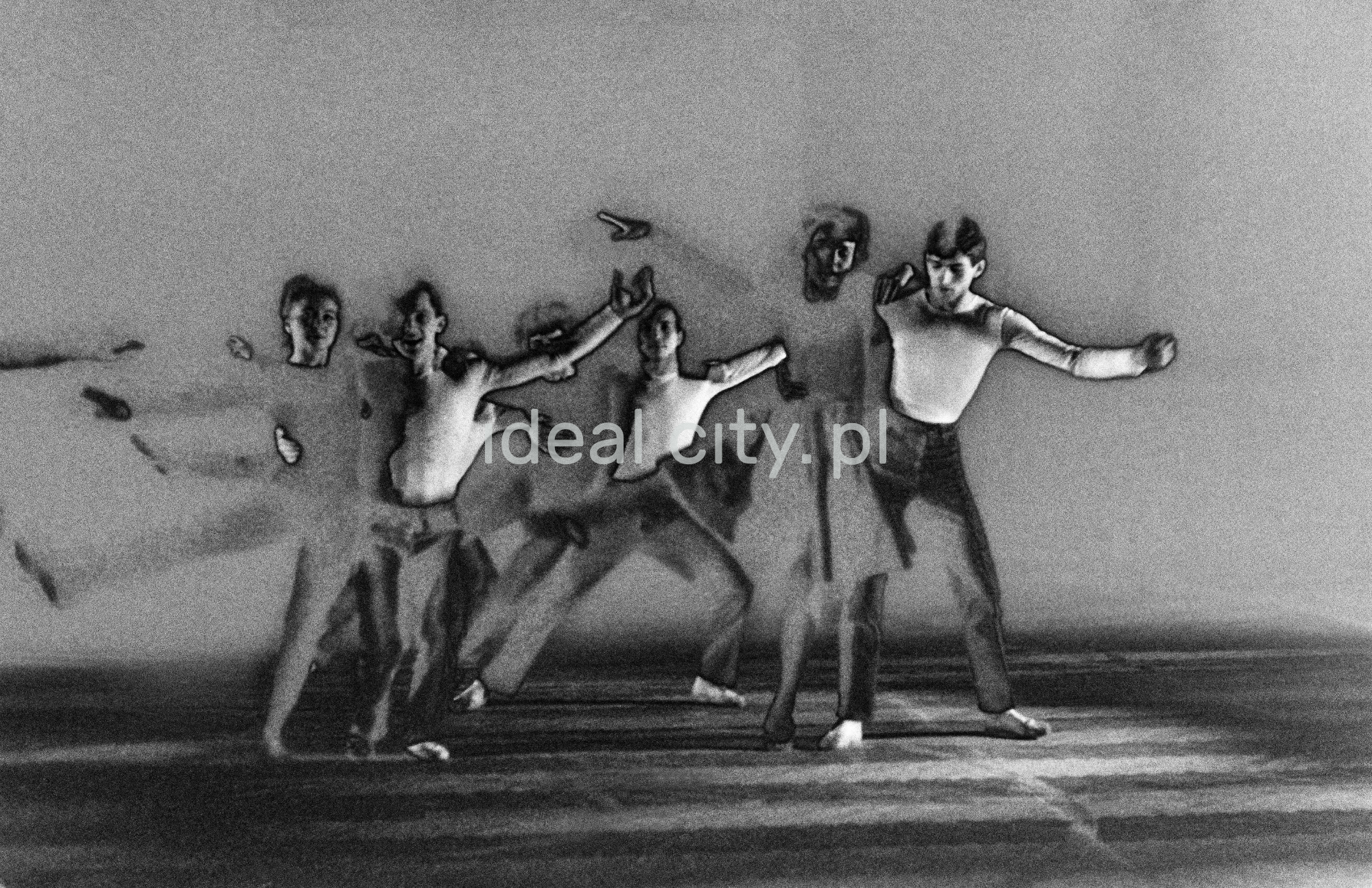 A group of dancers in tight-fitting costumes perform a collective figure on stage with a black background. The negative was solarized.