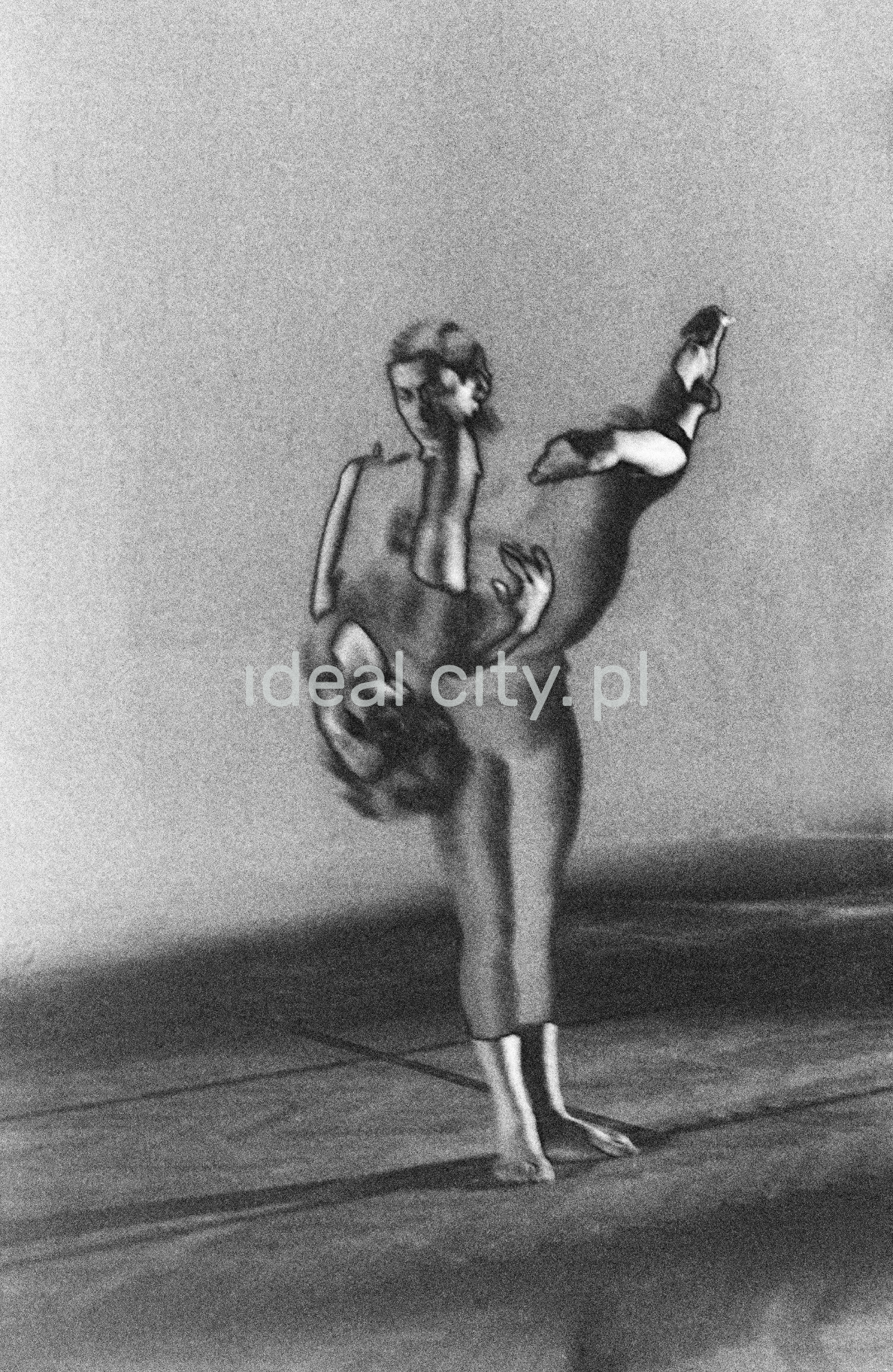 A group of dancers in tight-fitting costumes perform a collective figure on stage with a black background. The negative was solarized.