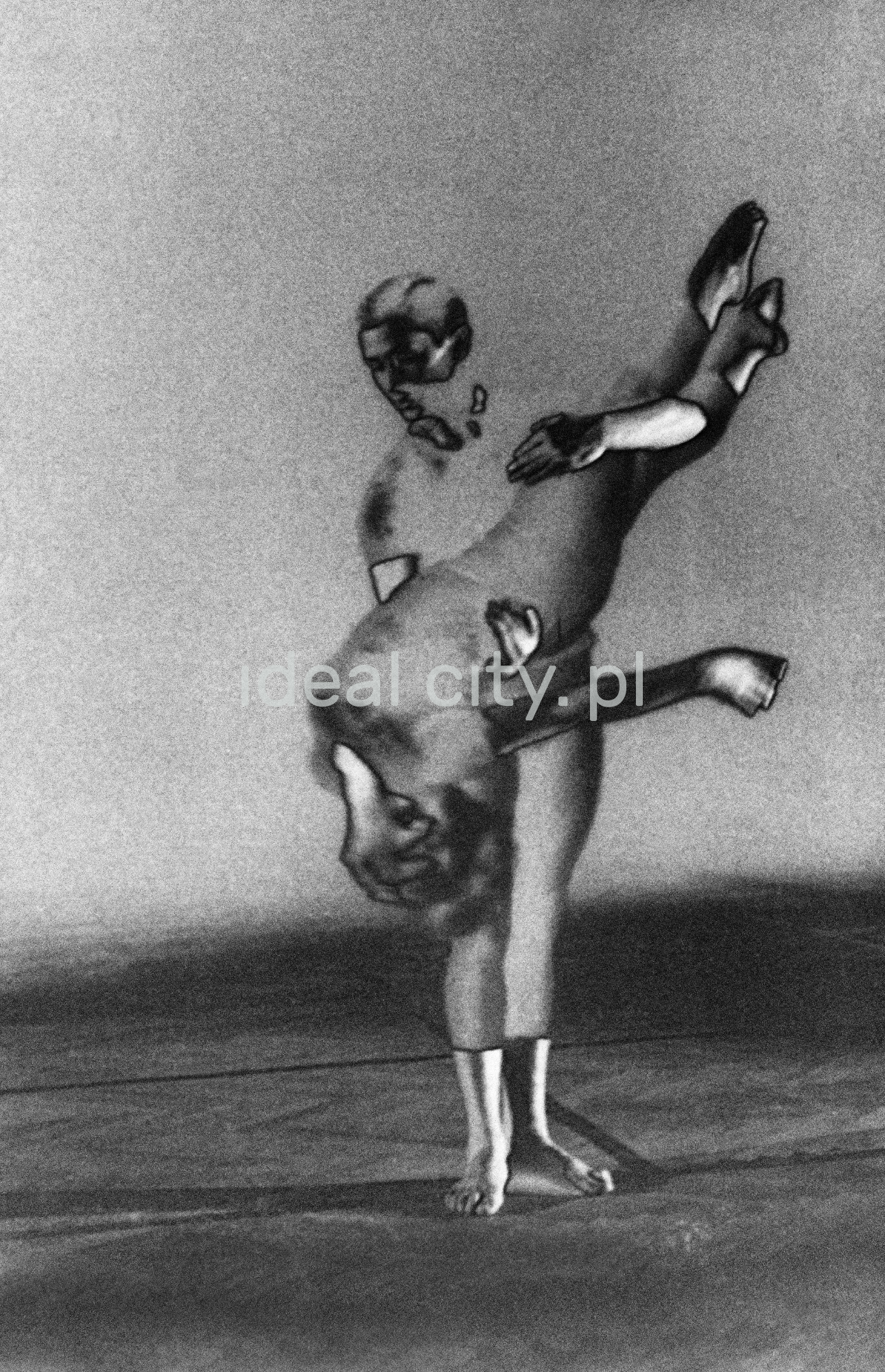 A group of dancers in tight-fitting costumes perform a collective figure on stage with a black background. The negative was solarized.
