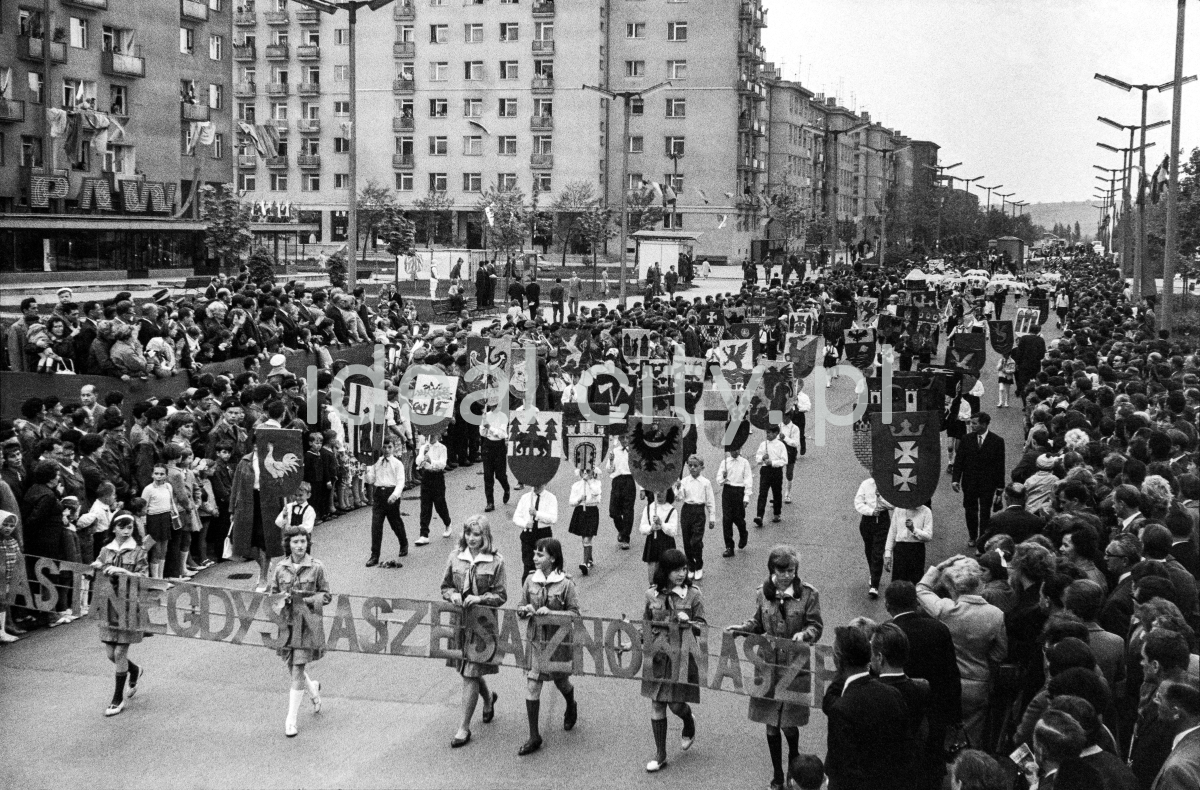 Children marching along a wide alley with the inscription: The cities that used to be ours are ours again.