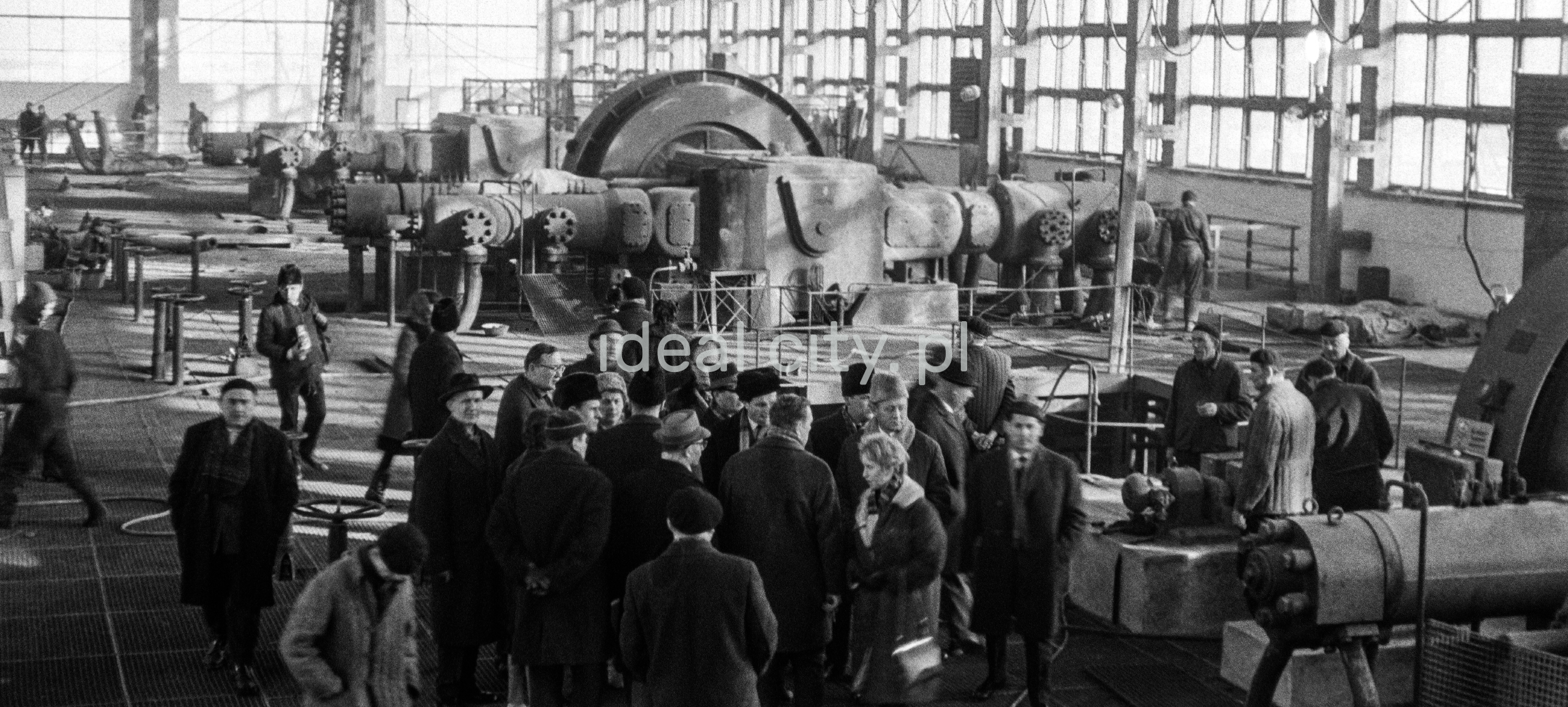 Delagats in coats visit the factory hall.