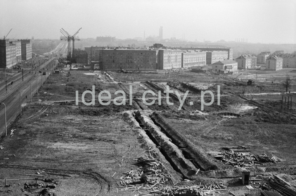 Top view of the ditches for the foundations of the block, finished residential buildings in the background.