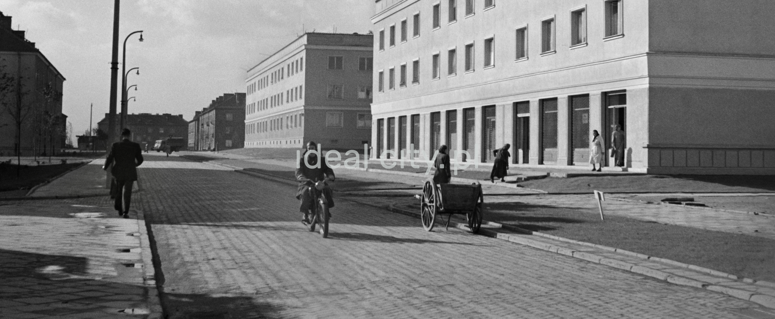 65/5000 Pedestrian and motorbike traffic on the street, low blocks on both sides.