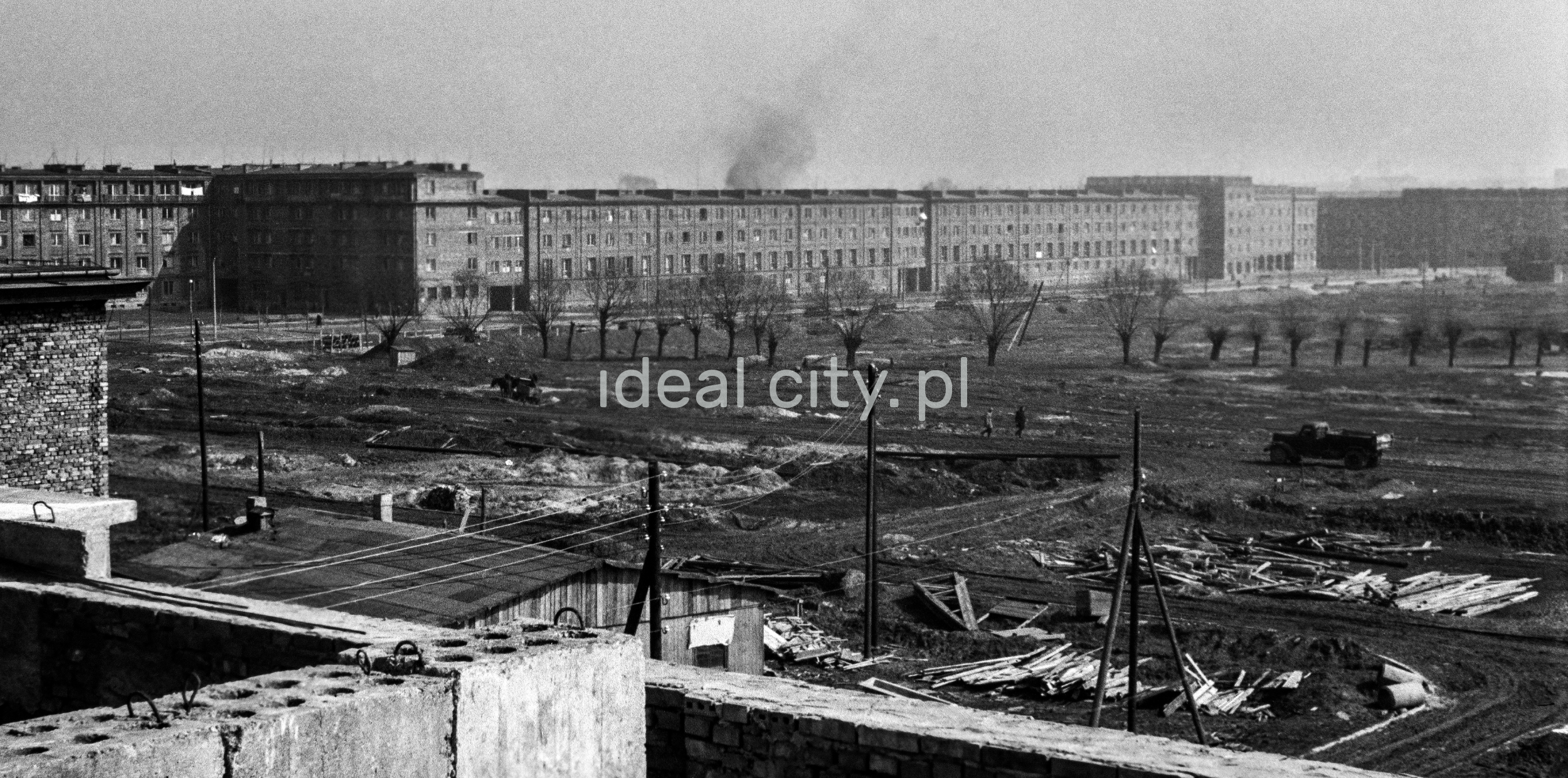 View of the construction site from above, apartment blocks in the background.