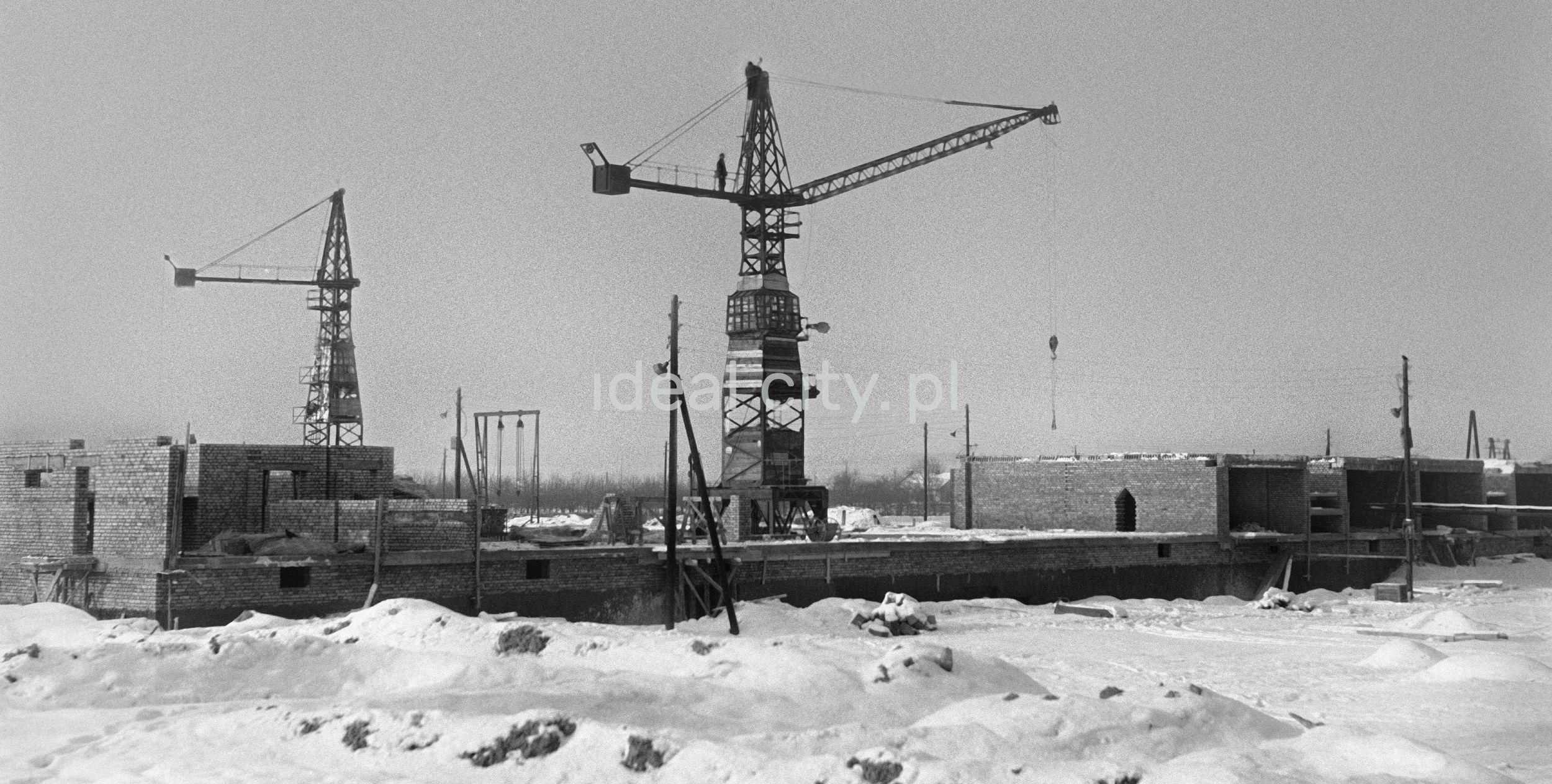 Winter view of two wooden construction cranes.