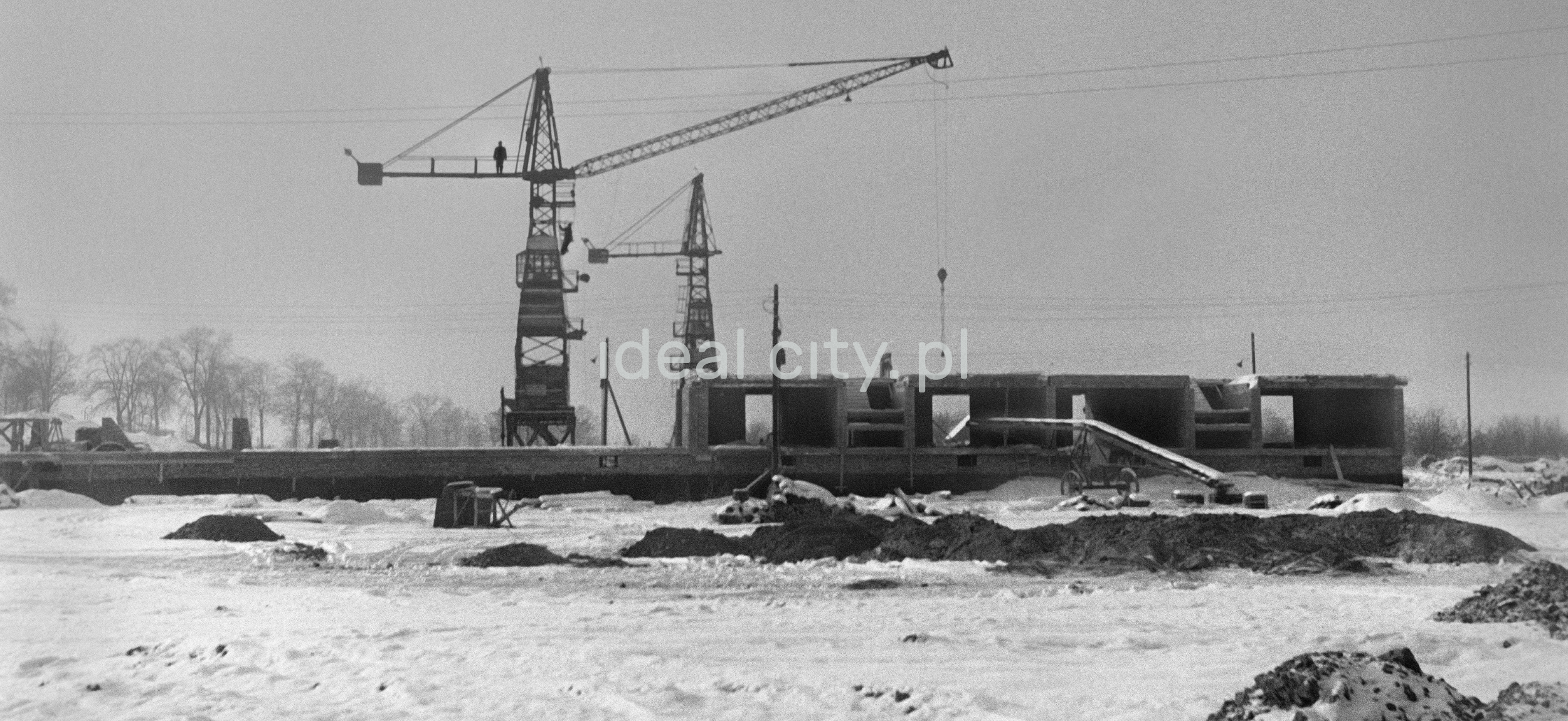 Winter view of two wooden construction cranes.