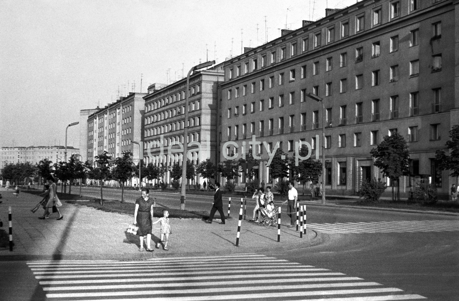 ittle pedestrian traffic around the intersection, in the background a massive block of flats
