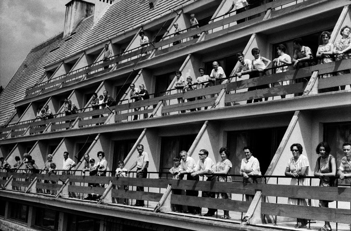 Ludzie na balkonach ośrodku wypoczynkowego pozują do zbiorowego zdjęcia