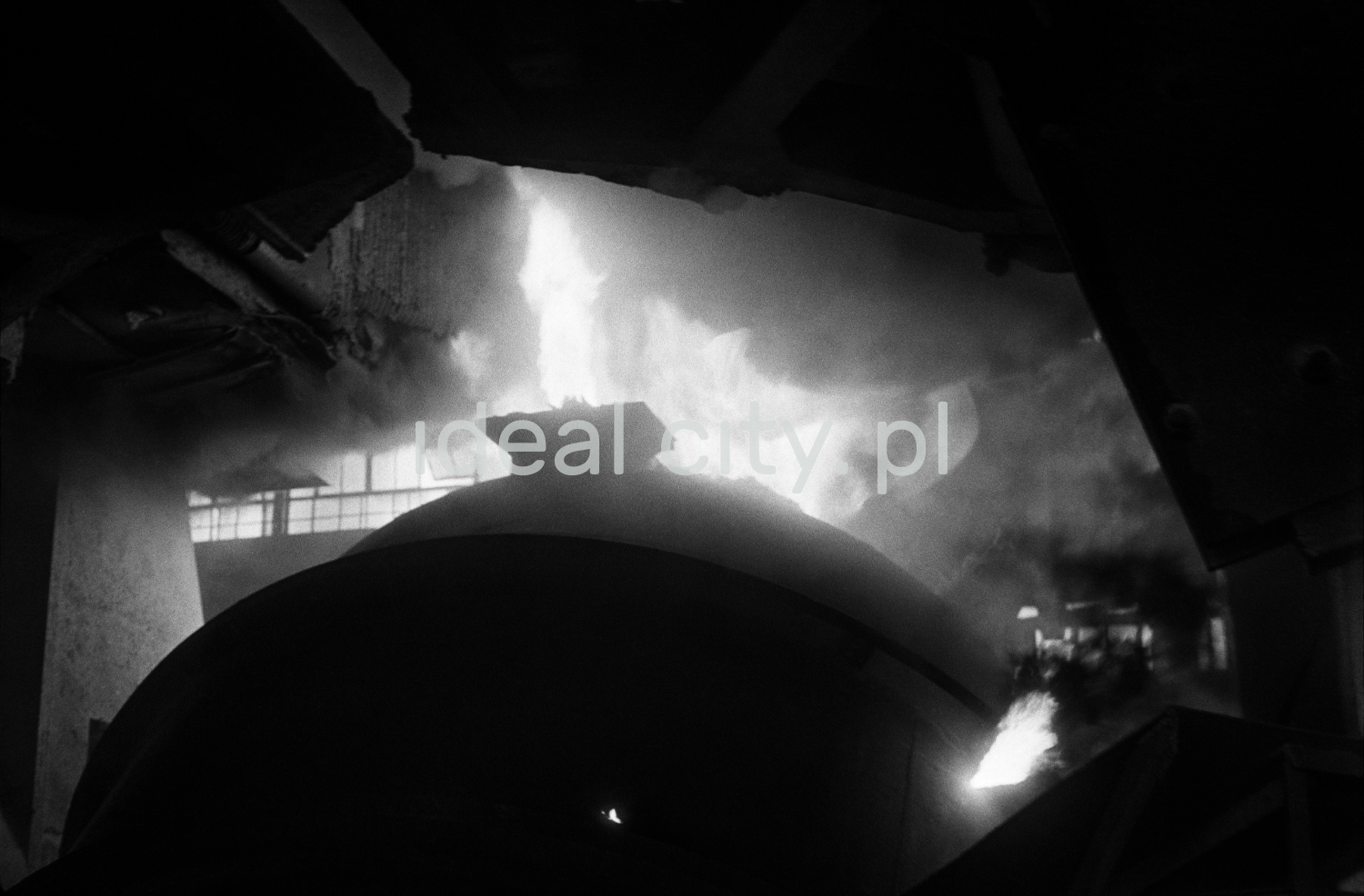 Fire bursts from the mouth of the mighty furnace at the top.