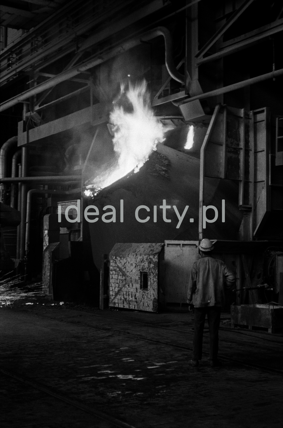 Fire bursts from the mighty, tilted vat.