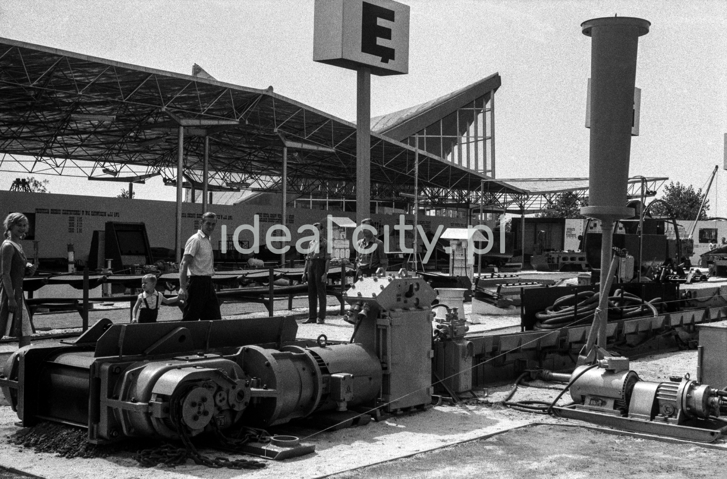 A view of the arrangement of the exhibition under the open sky, on a stand, a huge letter "Ę" visible in the center of the frame.