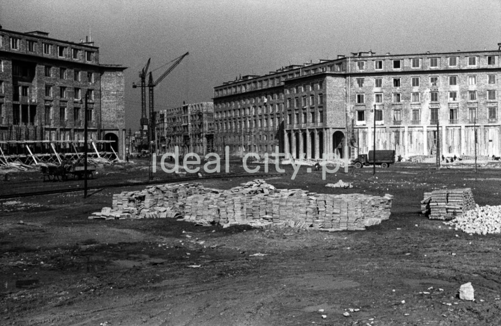 A view of a large city square under construction. Monumental apartment blocks in the background.
