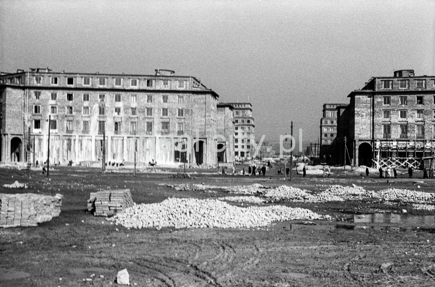 A view of a large city square under construction. Monumental apartment blocks in the background.
