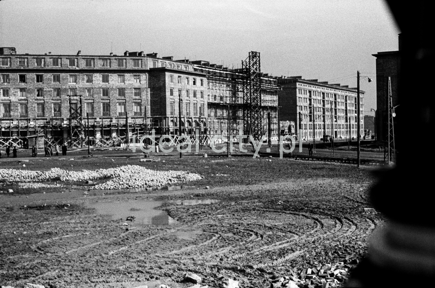 A view of a large city square under construction. Monumental apartment blocks in the background.