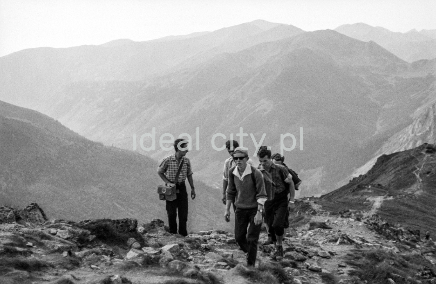 Backpackers go up along the rocky trail.