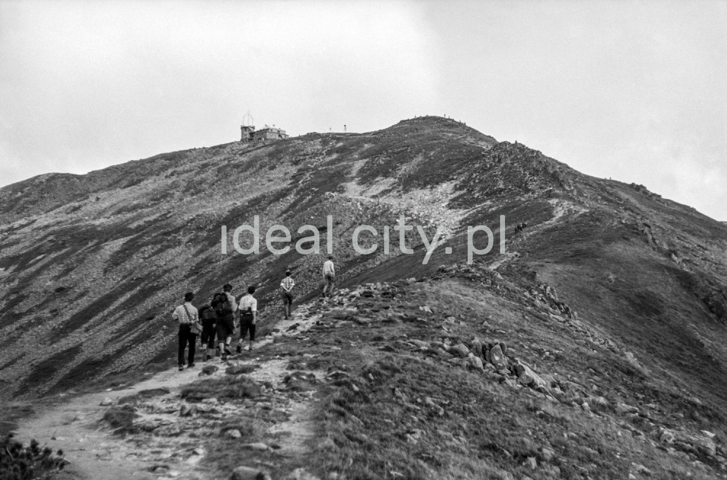 Backpackers go up along the rocky trail.