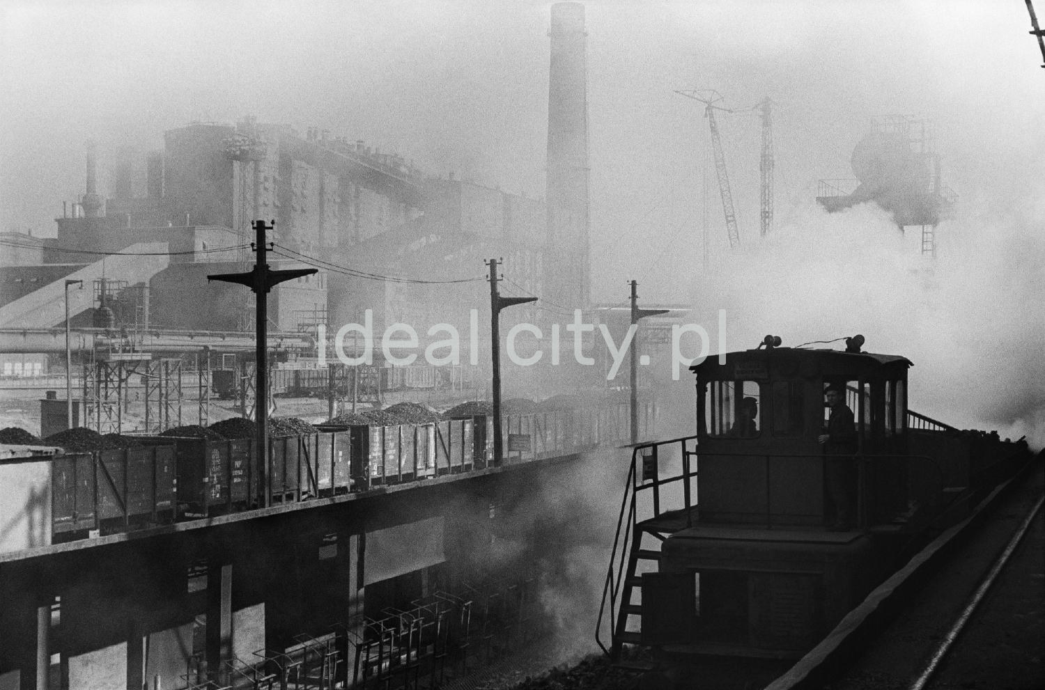 A view of the infrastructure of the coke chemical department, in the fumes of smoke, two people can be seen in the operator's booth.