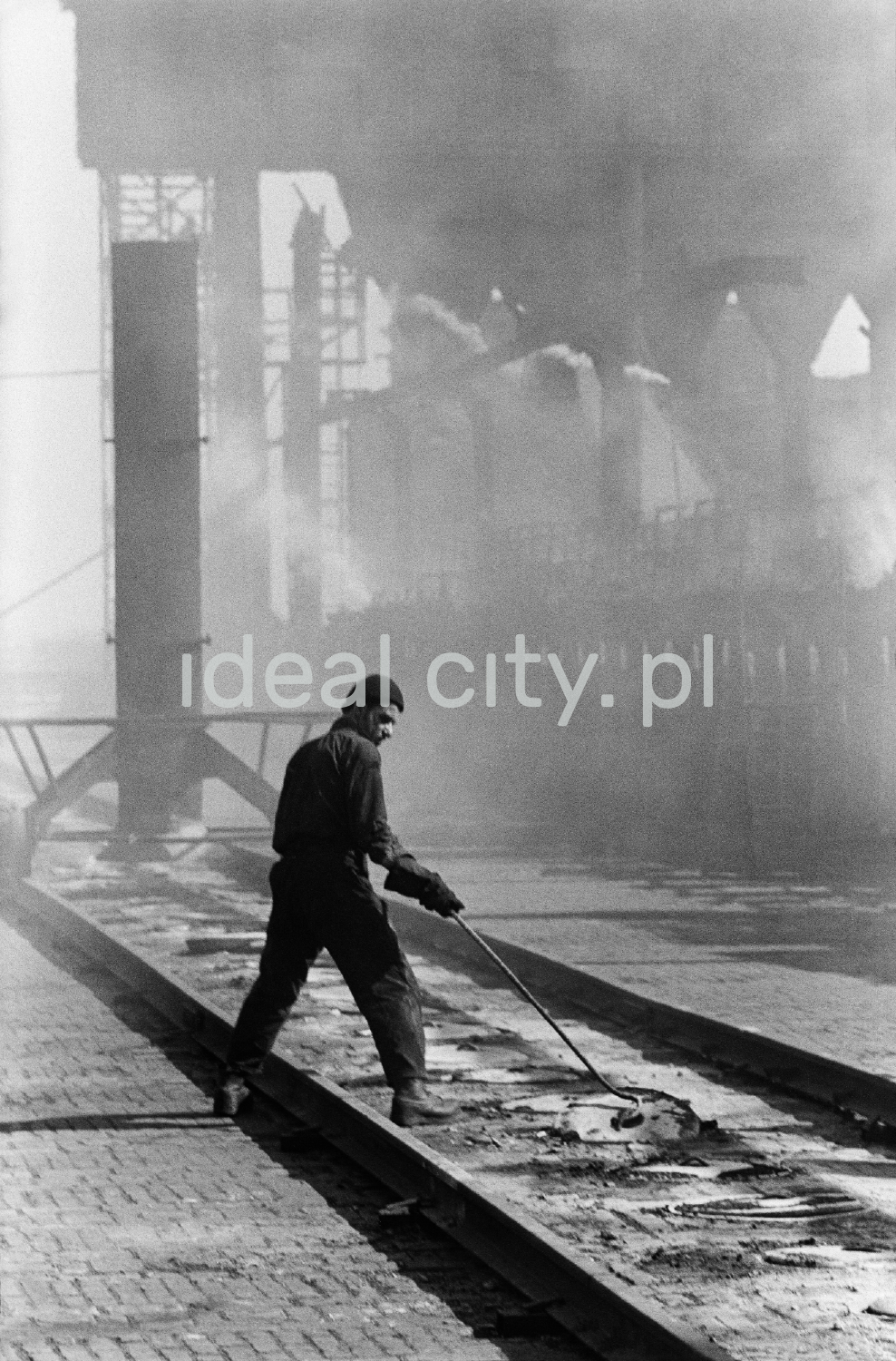 A man in denim oversees the cover of the coking plant.