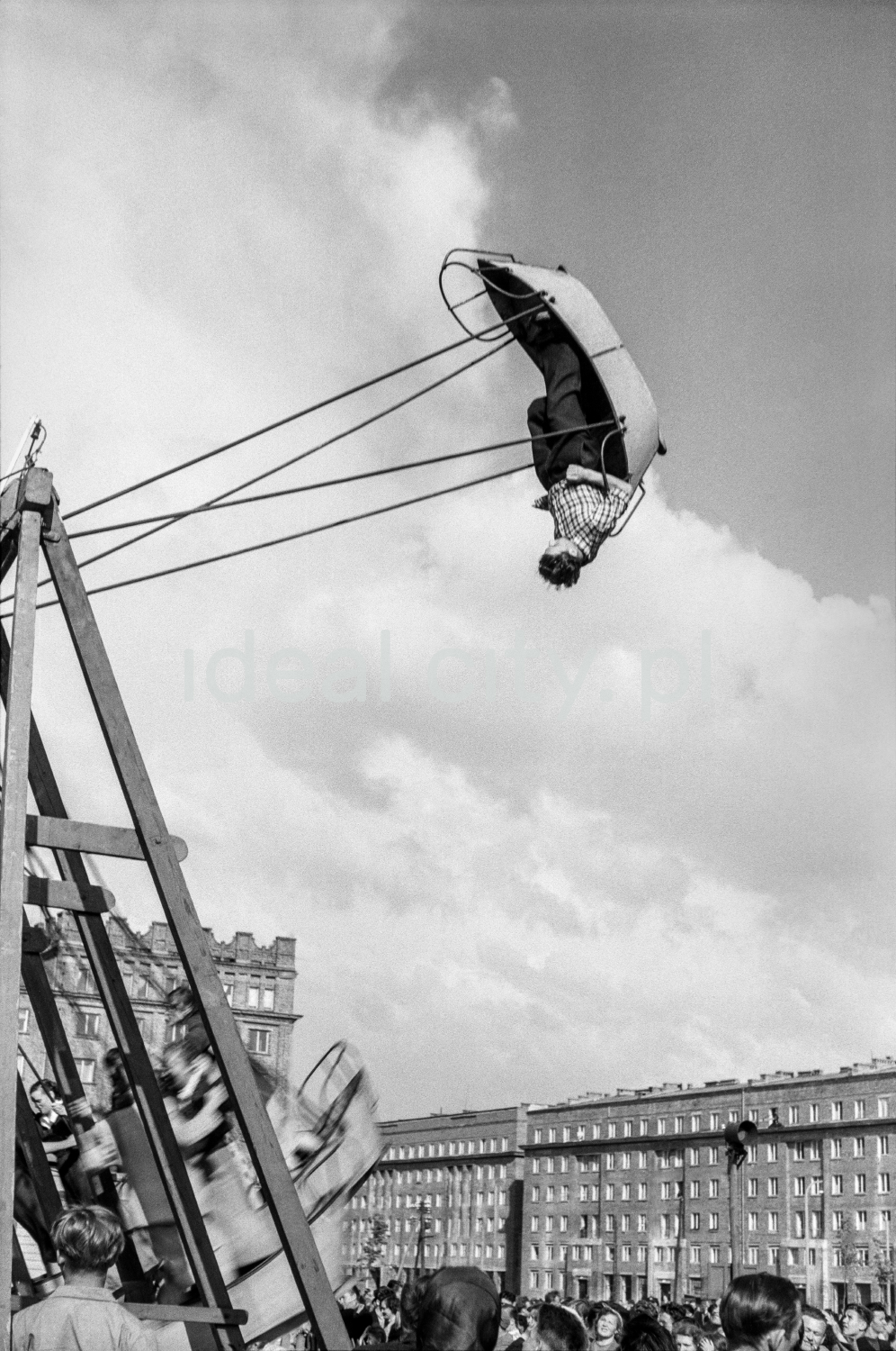 The man in the boat-shaped swing leans to the extreme position.