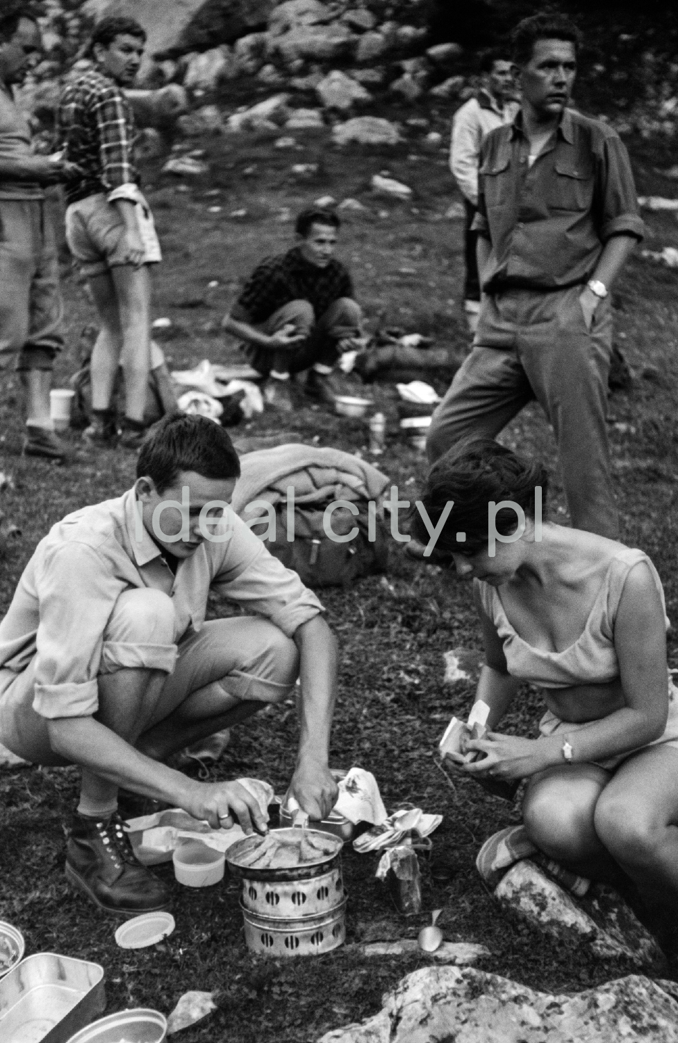 Tourists prepare a hot meal on the mountain trail.
