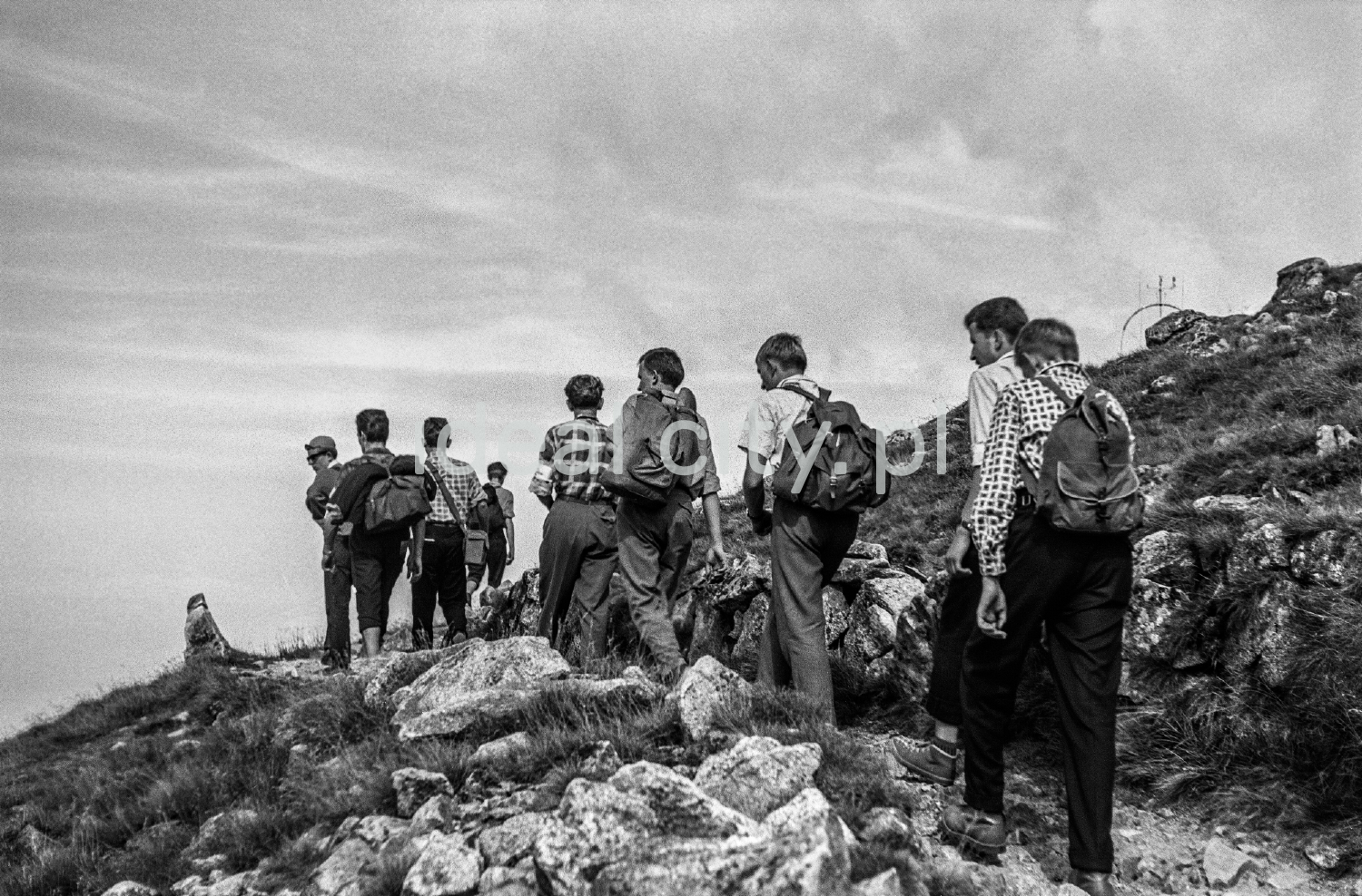 Backpackers go up along the rocky trail.