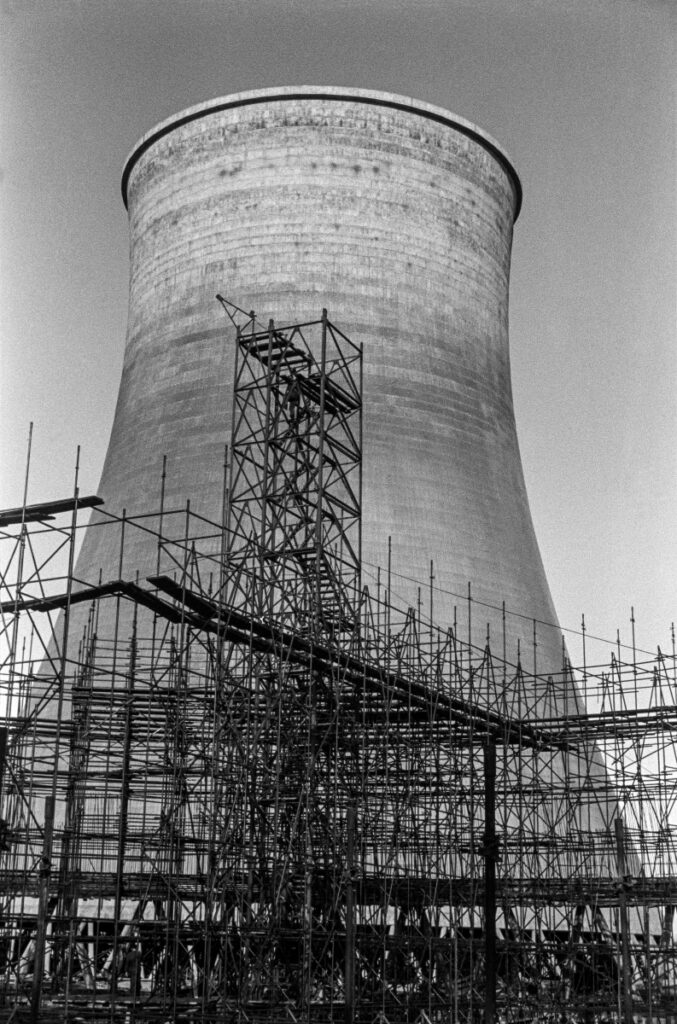 View of a cooling tower surrounded by scaffolding.