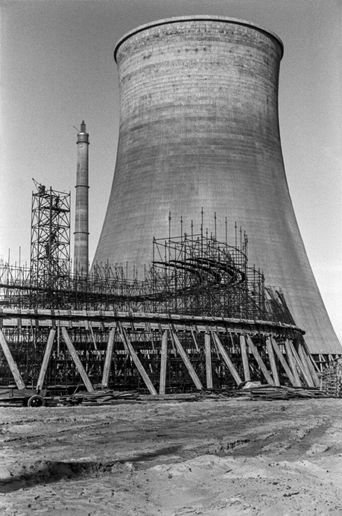 View of a cooling tower surrounded by scaffolding.