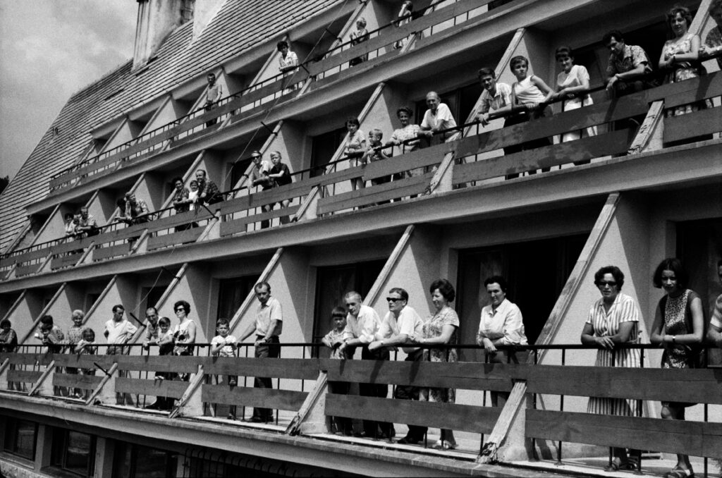 People posing to the group photograph on the hotel balconies.