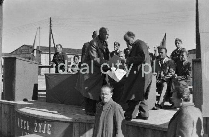 An awards ceremony; awards were given to young volunteers from the 91st and 92nd Brigades by the manager of the Department for Vocational Education at the Urban Construction Union. The ceremony took place at the site of today’s Kościuszkowskie Estate, where the volunteers (junacy) were stationed in 24 barracks. Ca. 1951.

Wręczenie nagród junakom z brygady nr 91 i 92 przez kierownika działu szkolenia zawodowego Zjednoczenia Budownictwa Miejskiego. Uroczystość odbyła się na terenie obecnego osiedla Kościuszkowskiego, gdzie znajdowały się 24 baraki będące siedzibą junaków. Około 1951.

Photo by Wiktor Pental/idealcity.pl

