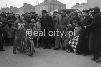 Motocykle na Placu Pocztowym na osiedlu A-1 Północ (Willowe), wyścig motocyklowy. W styczniu 1950 roku został zlikwidowany Automobilklub Polski. Na jego miejsce powstał Polski Związek Motorowy (jako efekt połączenia Automobilklubu Polski z 1909 roku i Polskiego Związku Motocyklowego z 1924 roku). Chcąc ratować AP wraz z PZM postanowiono wystąpić do Ministra Komunikacji o wprowadzenie Automobilklubu do Rady Turystycznej jako przedstawiciela turystyki motorowej oraz włączenie AP do planu 6 – letniego. Uchwalono wspólne postanowienia, takie jak przebudowa struktury organizacji (włączenie ośrodków wiejskich), zaproszenie do Zarządu działaczy ZMP, przeszkolenie działaczy zgodnie z intencjami władz PZPR, powołanie ośrodków dla młodzieży robotniczej i wiejskiej, jak również zakupienie dla najbardziej zdolnych sprzętu oraz udostępnienie pomocy technicznej. Powołano wspólnie odnowioną organizację czyli PZM. Z początkiem 1956 roku Zarząd Główny PZM wydał wytyczne do reorganizacji terenowych agend. Zarządy Okręgowe przystąpiły do organizacji „Automobilklubów”, które powstały w miejscu Ośrodków Szkolenia. Automobilkluby miały za zadanie, oprócz działalności sportowej, rozwijać struktury szkoleniowe ze sprzętem i zapleczem oraz pełnić dalej rolę organizatorów imprez. W ten sposób powstały kolejne organizacje w ramach PZM, m.in.: Automobilklub Kraków czy Automobilklub Nowa Huta z siedzibą przy ul. Klasztornej 1.  W 1957 roku PZM dokonał kolejnej reorganizacji oddziałów. Powołano ponownie Automobilklub Polski oraz wojewódzkie oddziały Automobilklubów. 1 czerwca 1957 roku w Krakowie reaktywowano Automobilklub Krakowski oraz przejęto lokal w Nowej Hucie po tamtejszym klubie, tworząc Ośrodek Techniczny. II połowa lat 50. XXw.

fot. Wiktor Pental/idealcity.pl



