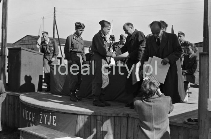 An awards ceremony; awards were given to young volunteers from the 91st and 92nd Brigades by the manager of the Department for Vocational Education at the Urban Construction Union. The ceremony took place at the site of today’s Kościuszkowskie Estate, where the volunteers (junacy) were stationed in 24 barracks. Ca. 1951.

Wręczenie nagród junakom z brygady nr 91 i 92 przez kierownika działu szkolenia zawodowego Zjednoczenia Budownictwa Miejskiego. Uroczystość odbyła się na terenie obecnego Osiedla Kościuszkowskiego, gdzie znajdowały się 24 baraki będące siedzibą junaków. Około 1951r.

Photo by Wiktor Pental/idealcity.pl

