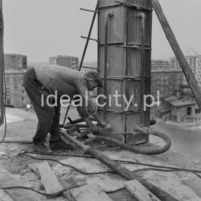 Robotnik (betoniarz) przygotowuje węże do betonowania filarów na budowie domu mieszkalnego na Osiedlu Centrum D, lata 50. XXw.

fot. Wiktor Pental/idealcity.pl


