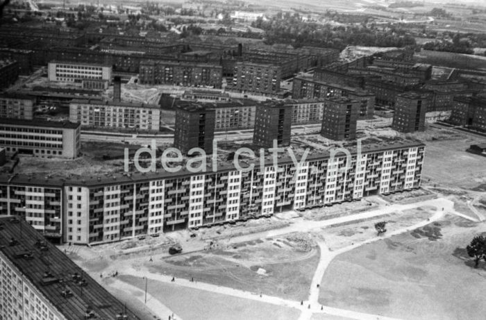 Fotografia lotnicza przedstawiająca zabudowę osiedli w strefie B. Na pierwszym planie plac na osiedlu Szklane Domy (B-32) z modernistycznym Blokiem Szwedzkim. Zaprojektowany został przez Janusza i Martę Ingardenów w 1956 roku, budowany w latach 1957-1959. Przy jego budowy nie używano cegieł, ale betonu komórkowego (na licencji szwedzkiej) Siporex. Pozwoliło to na zbudowanie loggii, gęsto ułożonych okien oraz balkonów. Do ozdobienia elewacji użyto kolorowych tynków, co wówczas należało do rzadkości. W długim na 260 metrów bloku wybudowano 272 nowoczesne i funkcjonalne mieszkania, na dole zaś umieszczono punktu usługowe (sklep motoryzacyjny, pasmanterię, drogerie i sklep nasienno-warzywniczy). Projektantami wnętrz byli Irena Pać-Zaleśna, Zdzisław Szpyrkowski i Kazimierz Syrek. Za Blokiem Szwedzkim domy mieszkalne oraz budynki użyteczności publicznej na osiedlu Słonecznym (B-33), Zielonym (B-2 Południe) oraz z prawej strony na osiedlu Szkolnym (B-1). Początek lat 60. XXw.

fot. Henryk Makarewicz/idealcity.pl


