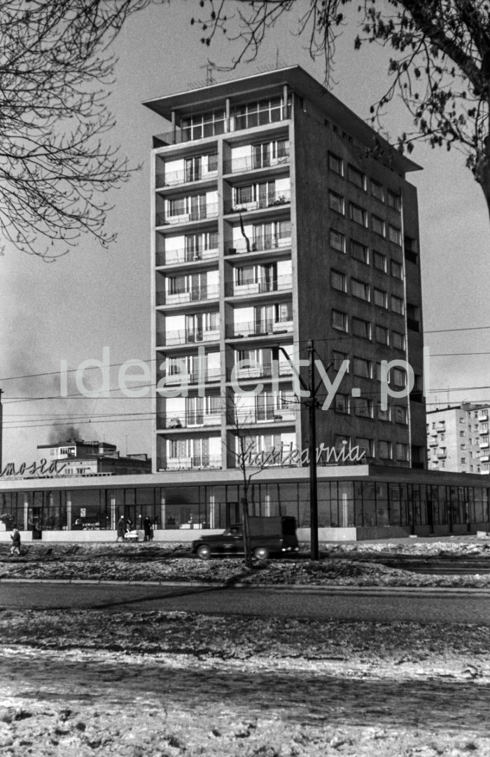 Osiedle Centrum D (D-31), widok od strony alei Planu 6-letniego (obecnie aleja Jana Pawła II).  Blok nr 7 (obecnie nr 8) czyli tzw. helikopter.. Autorami projektu byli Kazimierz Chodorowski i Stefan Golonka. Został wybudowany w nowej, „poodwilżowej” formie, tuż przy socrealistycznej zabudowie placu Centralnego. Dziesięciopiętrowy punktowiec w poziomie parteru otoczony został pawilonem handlowo-usługowym o szklanej elewacji. Mieściła się w nim m.in.: cukiernia, która oficjalnie zwana była „Ciastkarnią Bambo”. Poza lokalami mieszkalnymi z dużymi oknami i loggiami, posiadał on obszerne pracownie artystyczne. W bloku tym miał pracownie i mieszkał autor fotografii Henryk Makarewicz, l.60.XX w.

fot. Henryk Makarewicz/idealcity.pl

