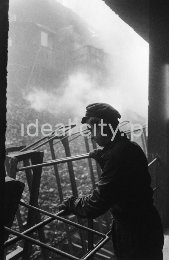 Lenin Metallurgical Combine, Coking Plant – pouring coke into cars. 1960s.
Coke is chiefly used for smelting iron in blast furnaces. Anthracite was coked in coke ovens invented in the 1940s. A group of such ovens was known as a coke oven battery.

Kombinat metalurgiczny im. Lenina, bateria koksownicza – wsypywanie koksu do wagonów, lata 60. XXw.
Koks wykorzystywany jest przede wszystkim w wytopie żelaza w wielkich piecach. Do koksowania węgla kamiennego służyły piece koksownicze wynalezione w latach 40. Zestaw takich pieców nazywał się baterią koksowniczą. 

Photo by Henryk Makarewicz/idealcity.pl


