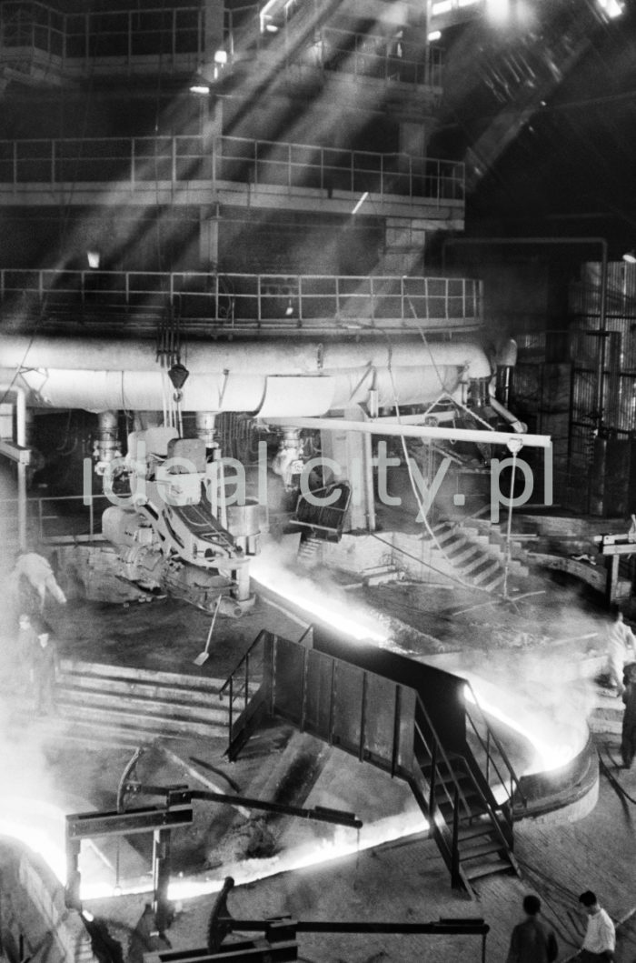 Lenin Metallurgical Combine. Blast Furnace – pig iron tapped off from blast furnace throat. 1960s.
The Blast Furnace is a steel structure (approximately 40m high) with refractory ceramic or coal lining. A mixture of ore, fuse elements, and coke is charged into the furnace from above. Hot air is blown into the hearth through special nozzles called tuyeres at the bottom.

Kombinat metalurgiczny im. Lenina, Wielki Piec – spust surówki z gardzieli Wielkiego Pieca, lata 60.
Wielki Piec to konstrukcja stalowa (ok. 40 m wysokości) wyłożona wewnątrz ceramicznym i węglowym materiałem ogniotrwałym. Od góry wprowadza się do niego mieszaninę rudy, topników oraz koksu, od dołu, poprzez dysze wiatrowe, wdmuchiwane jest podgrzane powietrze. 

Photo by Henryk Makarewicz/idealcity.pl



