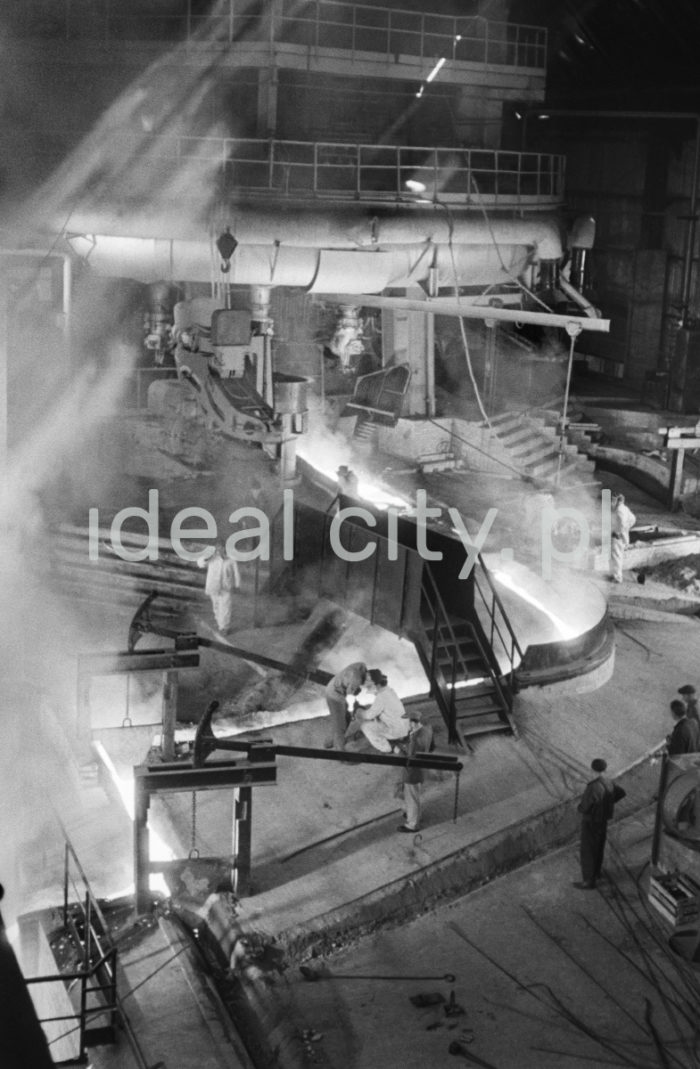 Lenin Metallurgical Combine. Blast Furnace – pig iron tapped off from blast furnace throat. 1960s.
The Blast Furnace is a steel structure (approximately 40m high) with refractory ceramic or coal lining. A mixture of ore, fuse elements, and coke is charged into the furnace from above. Hot air is blown into the hearth through special nozzles called tuyeres at the bottom.

Kombinat metalurgiczny im. Lenina, Wielki Piec – spust surówki z gardzieli Wielkiego Pieca, lata 60.
Wielki Piec to konstrukcja stalowa (ok. 40 m wysokości) wyłożona wewnątrz ceramicznym i węglowym materiałem ogniotrwałym. Od góry wprowadza się do niego mieszaninę rudy, topników oraz koksu, od dołu, poprzez dysze wiatrowe, wdmuchiwane jest podgrzane powietrze. 

Photo by Henryk Makarewicz/idealcity.pl



