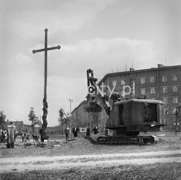 Attempt at removing a wooden cross put up at the site of a planned church on the Teatralne estate; the Teatr Ludowy in the background. The cross was a symbolic foundation for a church that was to be erected in Nowa Huta. In October 1959, the planning permission was withdrawn, and on 27 April 1960 the City Committee of the Polish United Workers’ Party (PZPR) decided the cross should be removed. 27 April 1960.

Próba usunięcia drewnianego krzyża postawionego w miejscy planowanej świątyni na Osiedlu Teatralnym – w tle widoczny Teatr Ludowy. Krzyż był symbolicznym fundamentem pod budowę nowohuckiego kościoła. W październiku 1959 roku cofnięto pozwolenie na budowę, a 27 kwietnia 1960 roku Komitet Miejski PZPR zdecydował o usunięciu krzyża. 27 kwietnia 1960 r.

Photo by Wiktor Pental/idealcity.pl

