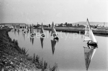 Parada żaglówek na Wiślem na wysokości Nowej Huty. Początki żeglarstwa w Krakowie-Nowej Hucie sięgają 1955r. Utworzono wówczas Zakładowy Klub Morski z czterema sekcjami: kajakową, wioślarską motorowodną i żeglarską przy Zjednoczeniu Przemysłowym Budowy Huty im. Lenina. Rozpoczęto również budowę przystani wodnej Nad Wisłą u wylotu ulicy Klasztornej.
22.07.1955 - uroczyste otwarcie przystani w nowo wybudowanych hangarach, a na wodę spłynęły oprócz kajaków 4 jachty: Omega, dwa Finny i BM.
W 1959r. nastąpiła zmiana nazwy Klubu na Yacht Klub „Budowlani